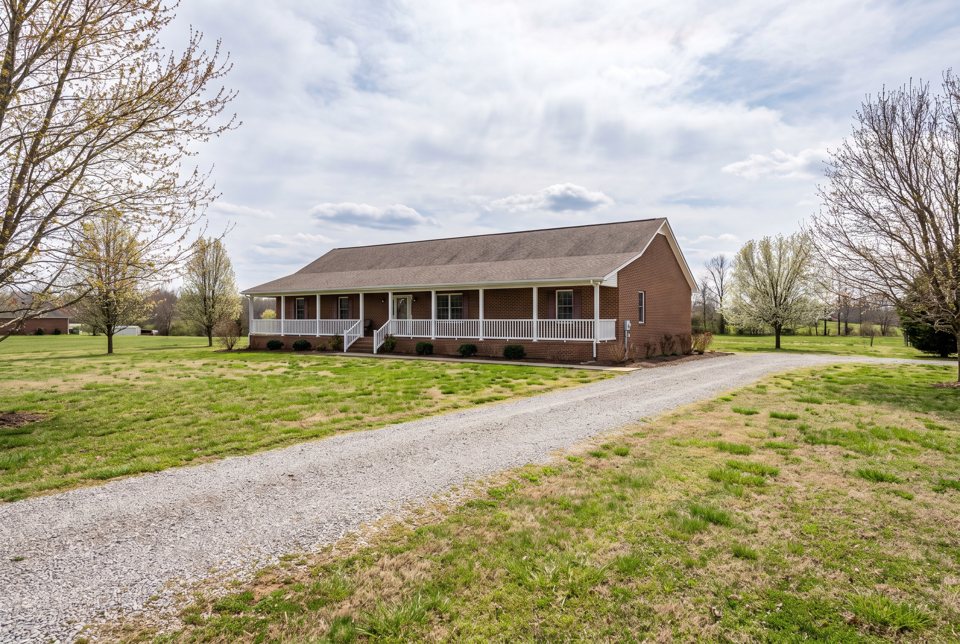 A brick house with a long covered porch and white railings in Union County