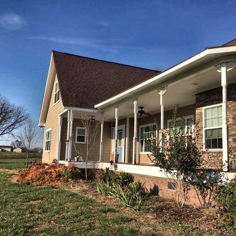 A single-story house with a long covered front porch, white columns and white railings