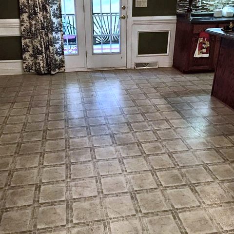 An open living and dining area with a new ceramic tile floor laid on the diagonal